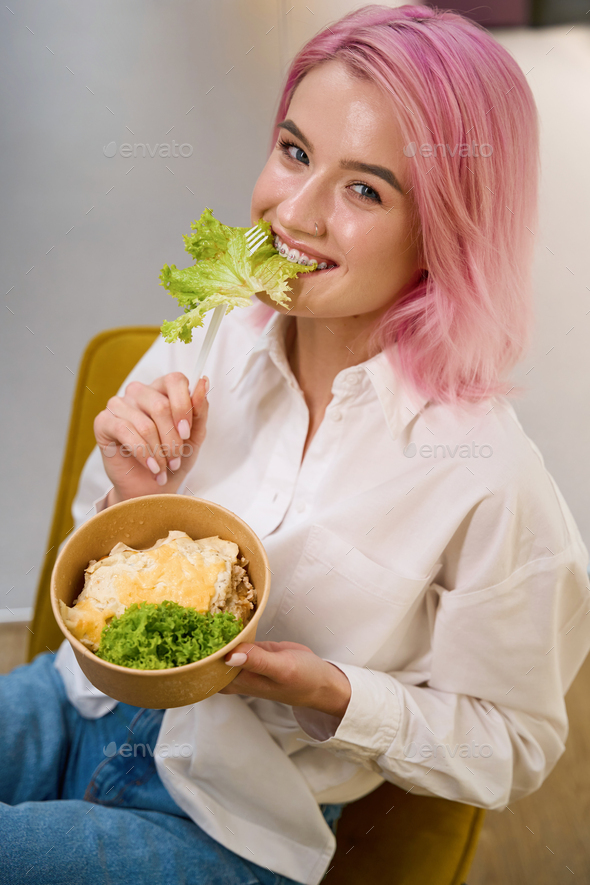 Happy lady having lunch and looking at the camera - Stock Photo - Images