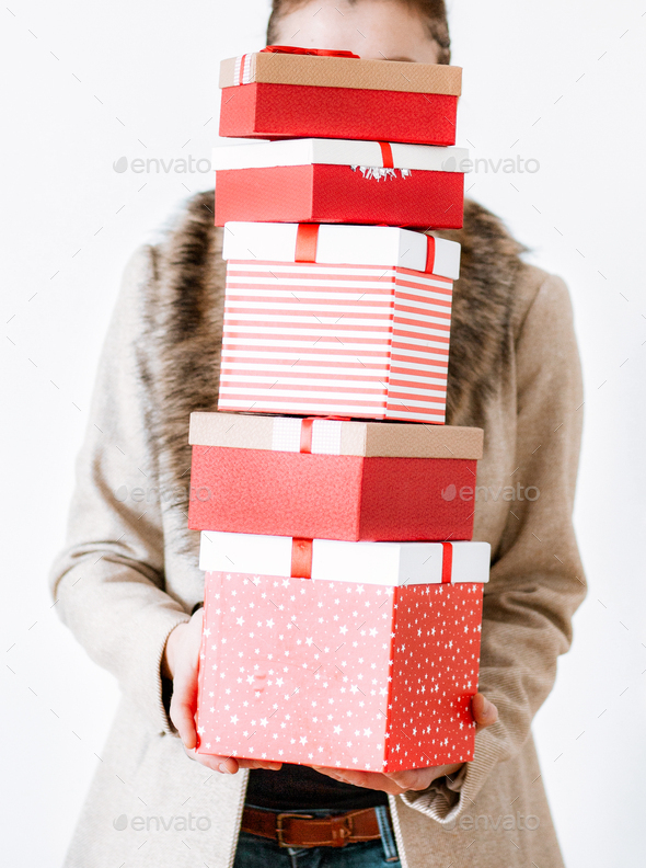 woman returning home from shopping holding pile of christmas present boxes