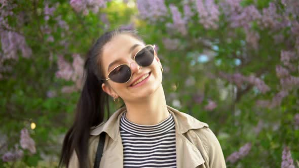 Young Woman Looking at Camera Lilac Background Spring Walking