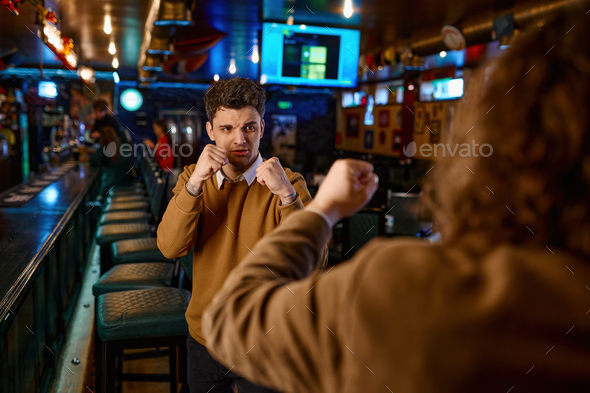 Angry male friends fighting at sport bar - Stock Photo - Images