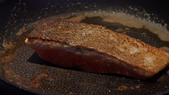 Frying Salmon Fillet Is Turned on a Pan - Closeup alt