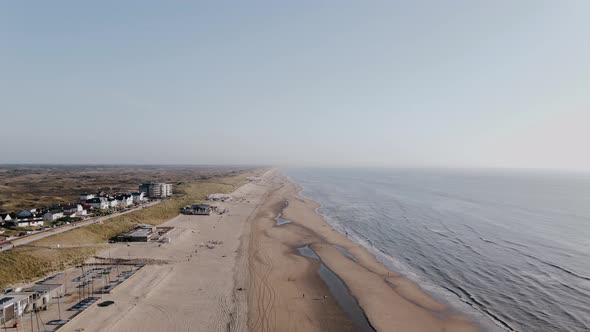 Drone Flies Over Ocean Beach Outside the City on a Summer Day