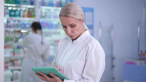 Portrait of Intelligent Focused Woman Checking Online List of Medications Comparing Stock on Shelves alt