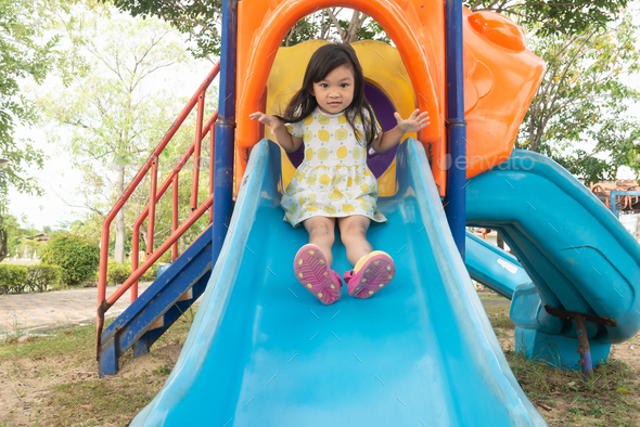 Asian child girl playing with slider bar toy at the park playground ...