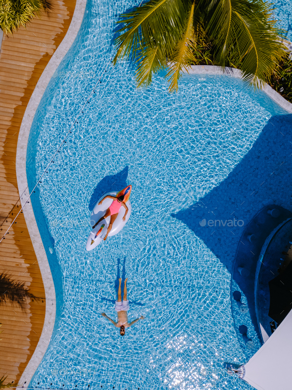 View from above at a swimming pool, couple men and women in swimming ...