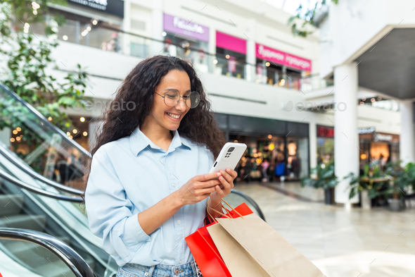 Happy woman shopping for clothes during the period of discounts and promotional offers, Hispanic
