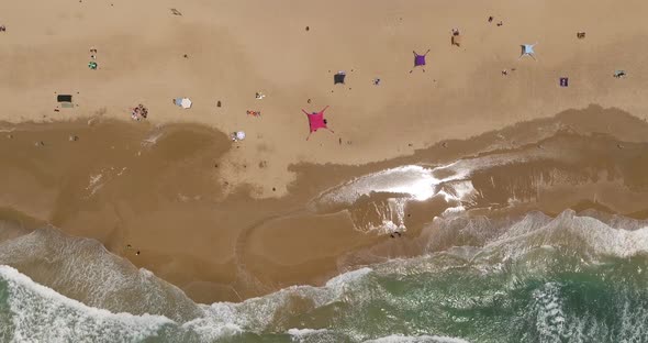 Crowded public beach with colourful umbrellas and people in the water and relaxing on the sand, Aeri alt