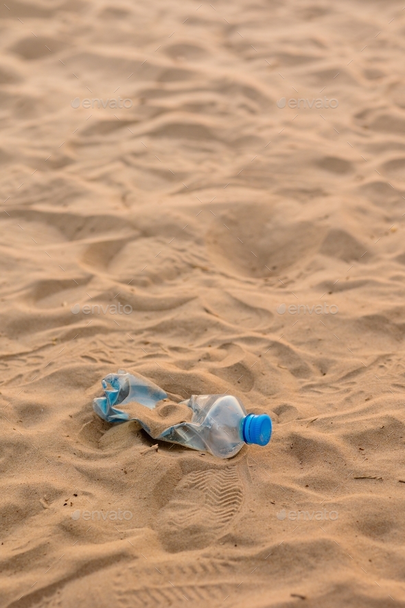 plastic bottle on the sand on the beach, eco Friendly, pick up trash in nature