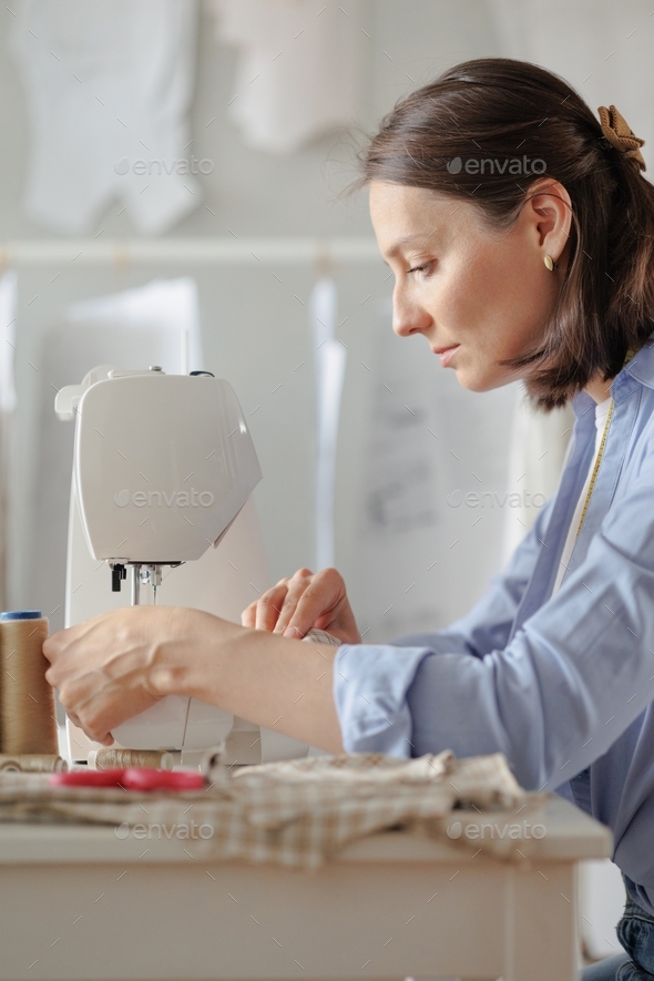 a European woman is a seamstress or a fashion designer in her workshop or atelier for sewing