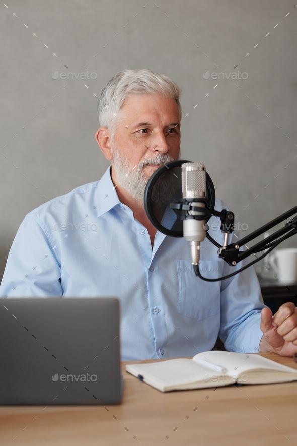  adult male with gray hair is a radio host with a microphone. senior records audio content