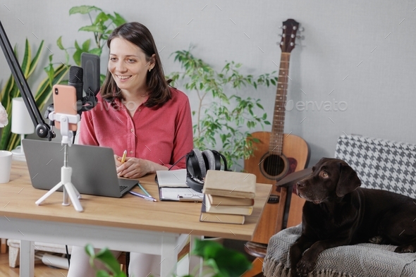 woman recording audio content microphone or a podcast for her blog in a home recording studio