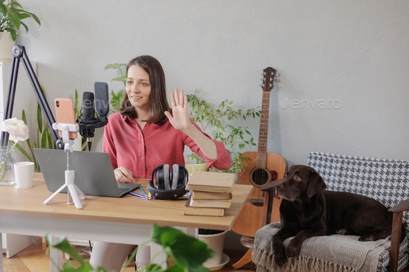 woman recording audio content microphone or a podcast for her blog in a home recording studio.