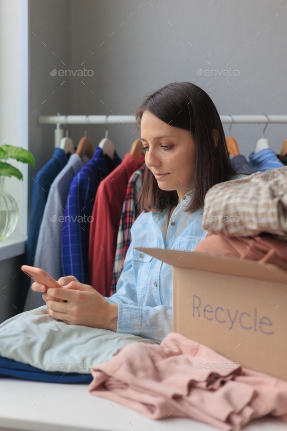 woman puts clothes in a recycling box. garbage sorting and an
