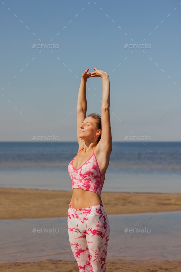 woman is engaged in sports fitness. warm-up and stretching muscle bend, pink tai dai sportswear
