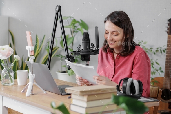 woman records audio content or a podcast for her blog in a home recording studio.