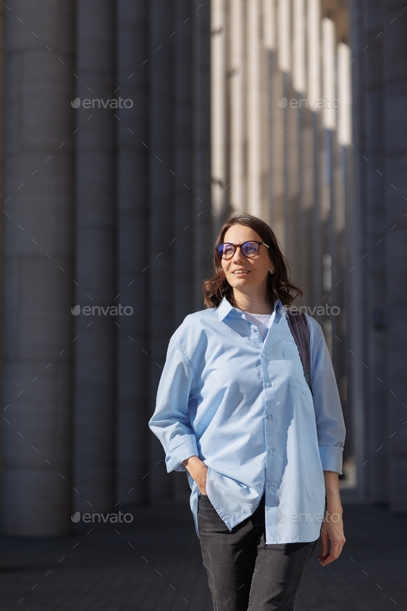 business woman in a blue shirt goes to work or to a meeting with colleagues and partners. a female