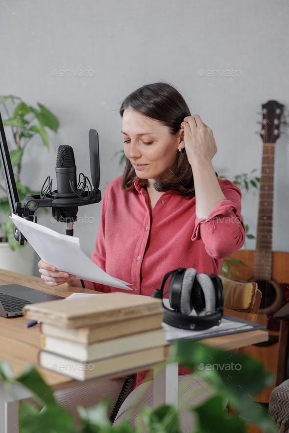 woman records audio content or a podcast for her blog in a home recording studio.