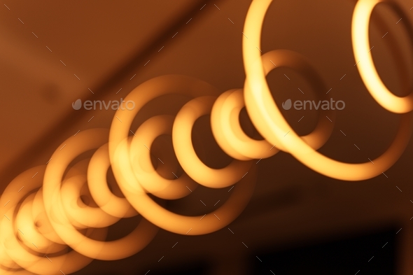 blurred hanging rings or circle bulb. abstract lighting modern geometry lamp glowing golden light - Stock Photo - Images