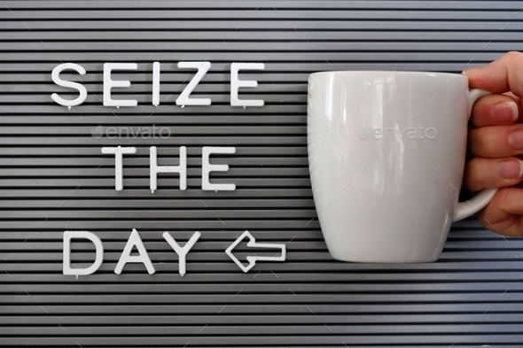 Message board saying Seize the day with a woman holding a coffee mug next to it.