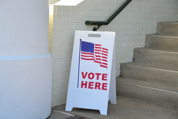 A sign showing folks where to vote outside a voting poll location. Vote Here entrance