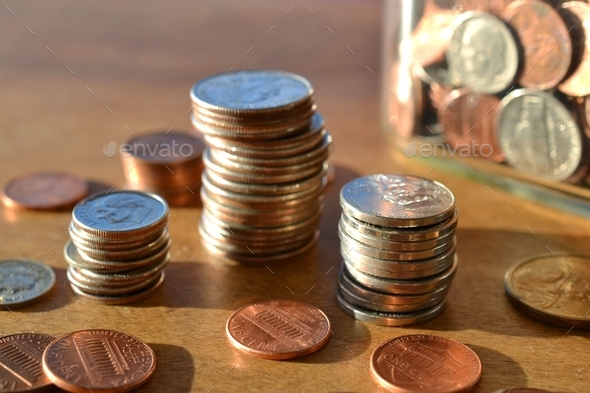 Stacks piles of spare change coins, pennies, dimes, nickels, quarters, loose change jar, saving