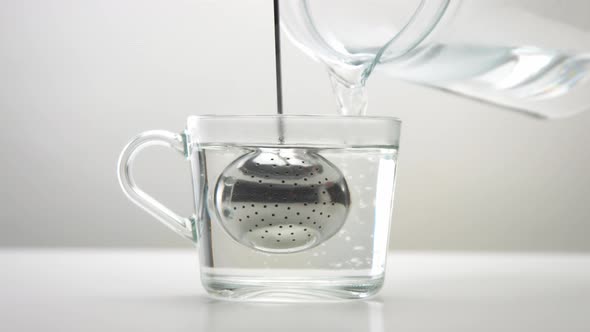 Transparent Cup with a Tea Infuser Spoon. Brewing Tea Minimalist Footage