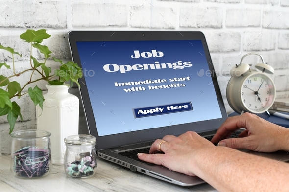 Female typing on laptop computer with Job Openings benefits Apply Here on screen Online Job Search