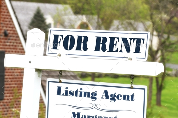 For Rent sign in front of a neighborhood with houses home in the background. - Stock Photo - Images