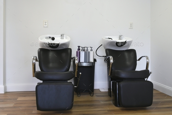 Hair washing shampooing station chairs seats sinks at a hair salon. no people, empty