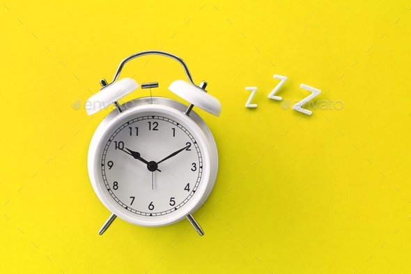 Alarm clock with ZZZ - concept sleep, bedtime, dreams, REM sleep, time to wake up, tired, snoring