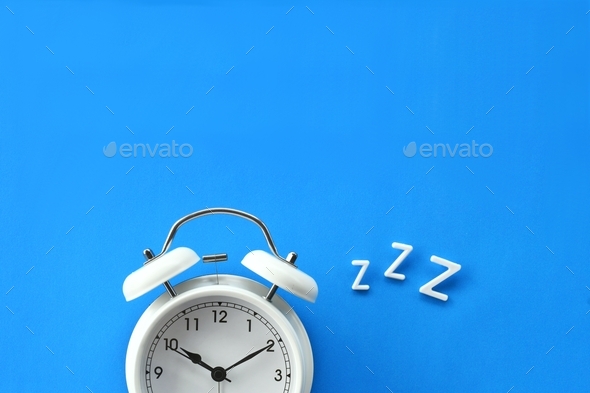 Alarm clock with ZZZ - concept sleep bedtime dreams REM sleep time to wake up tired snoring
