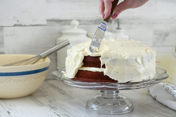 Spreading Cream Cheese Frosting Onto Homemade Layer Cake With An Offset Spatula In Bright