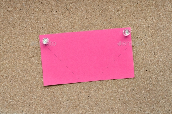 Blank pink note card pinned with push pins on a corkboard bulletin board for mock up own message