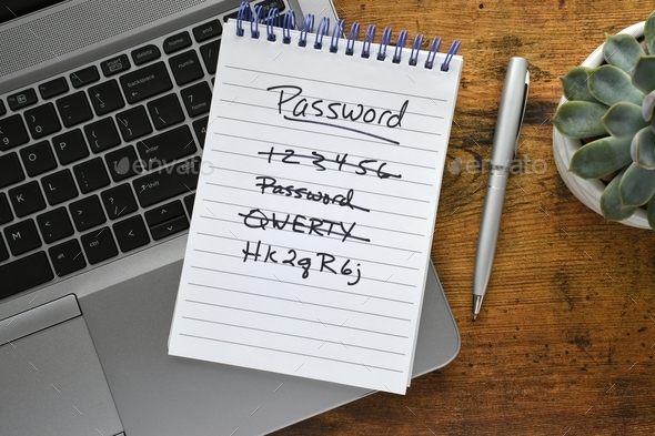 Password list on notebook laying on keyboard of laptop computer on desk. Security strong password - Stock Photo - Images