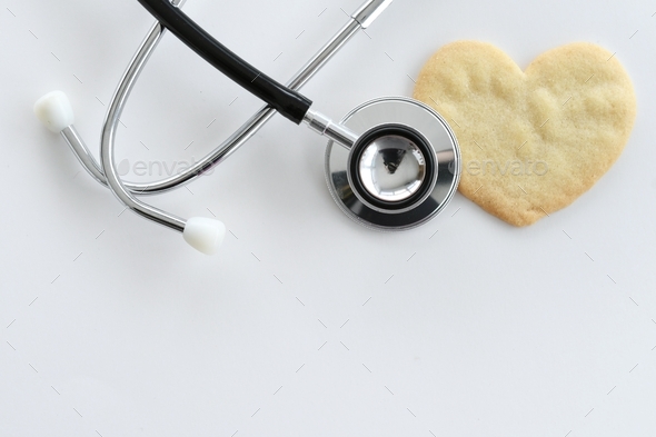 Heart health concept - stethoscope heart-shaped cookie on white, cardiac arrest, heart attack