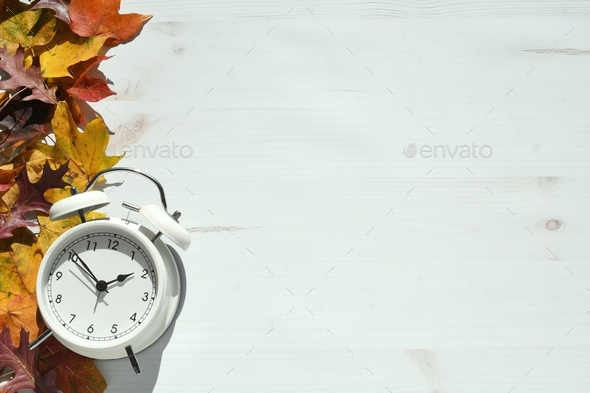 Autumn fall leaves with clock - concept for time change, fall back or last minute sales deals