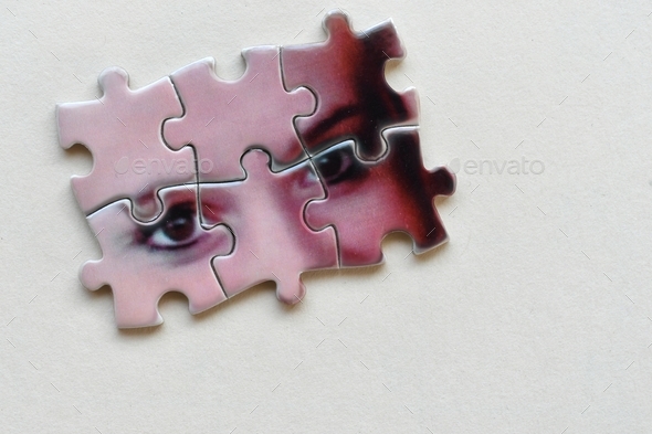 Mental health psychology concept - puzzle pieces with female\'s eyes