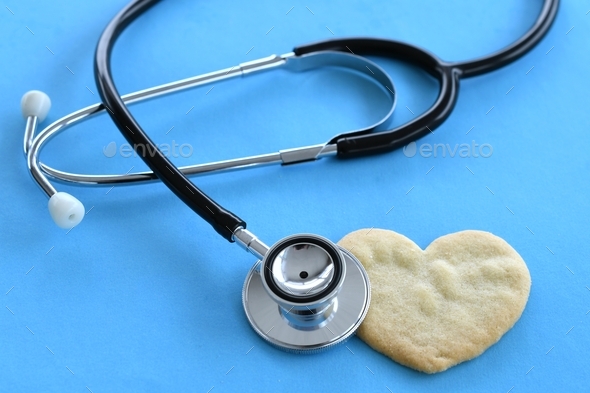 Heart health concept - stethoscope heart-shaped cookie on blue, cardiac arrest, heart attack