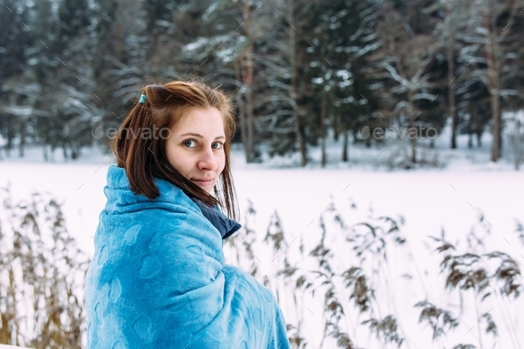 portrait of a woman in winter clothes on the nature. There is a