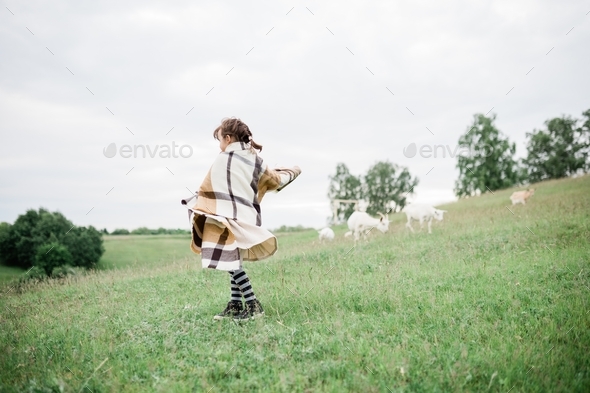 Young girl on the green hills on the farm - Stock Photo - Images