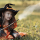 Little witch girl conjures magic wand on Halloween. - PhotoDune Item for Sale