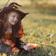 Little witch girl conjures magic wand on Halloween. - PhotoDune Item for Sale