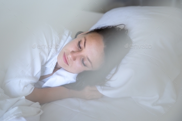 Beautiful young woman sleeping in white bed. Dreaming and relaxing time. - Stock Photo - Images