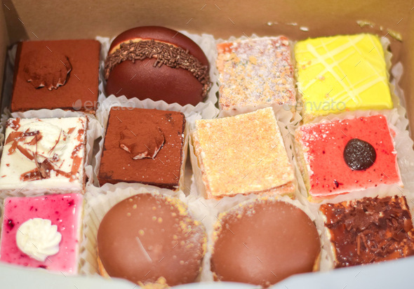 An assortment of colorful mini cakes in a box, take out, delivery food