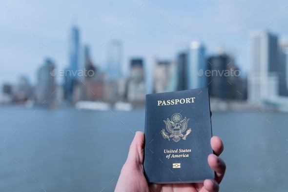 Passport in hand personal perspective with the New York City skyline in distance