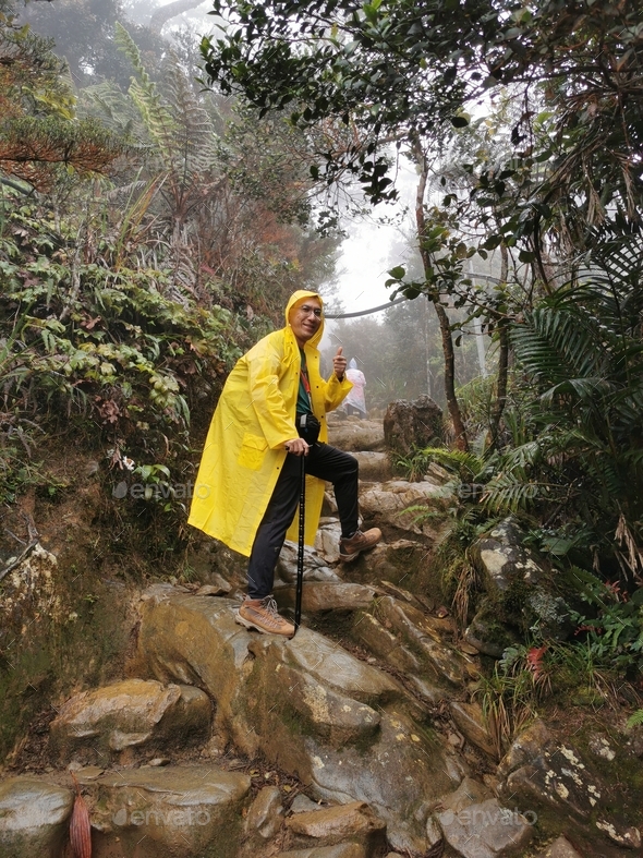 Portrait of an Asian man wearing yellow raincoat  - Stock Photo - Images