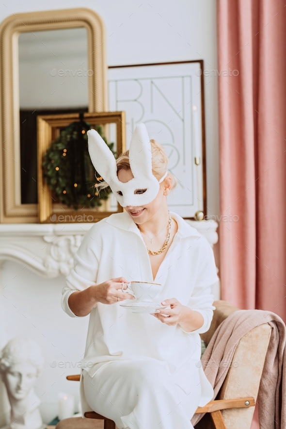 Beautiful young happy woman in carnival rabbit mask and white costume ...