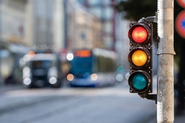 view of city traffic with traffic lights, in the foreground a semaphore with a red and yellow light - Stock Photo - Images