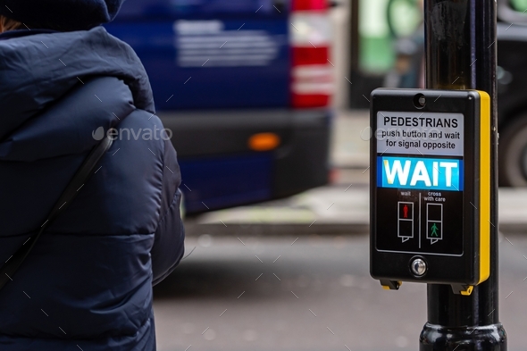 Crosswalk button for pedestrian with light warning on a defocused background, London, UK - Stock Photo - Images