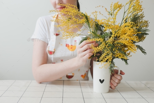  smiling woman with mimosa flowers on white background